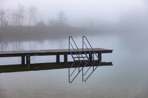 Foggy autumn atmosphere at the lake with wooden footbridge, Irrsee, Salzkammergut, Upper Austria,