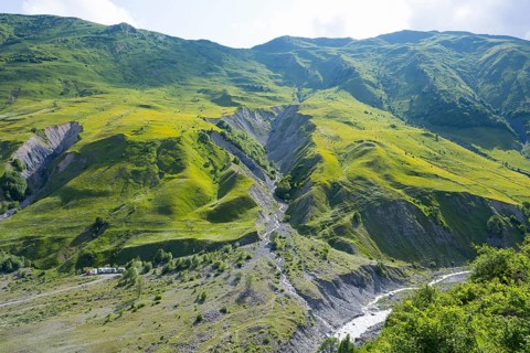 Green, steep landscape with a narrow river course in the mountains, landscape between Kvesheti and