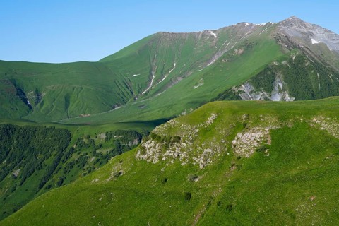 Green mountainside under clear sky, natural peace, landscape between Kvesheti and Gudauri,