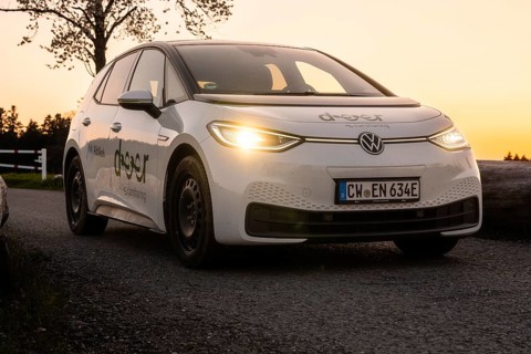 Car on country road at dusk with glowing headlights, VW ID3 electric car, deer e-car sharing, Calw,