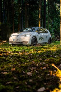 Car during the day in the forest on mossy ground, sunlight falling on the scene, VW ID3 electric