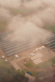 Construction site for solar systems, foggy environment with several construction site vehicles,