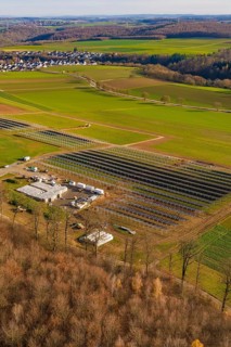 Solar system and building nestled in a green landscape with village surroundings in autumn, energy