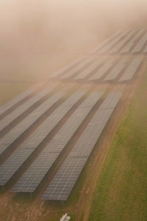 Landscape with solar panels in fog, atmospherically dense and sustainable, energy transition,