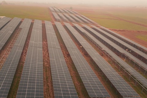 Extensive solar panel layout in foggy landscape, sustainable energy source, energy transition,