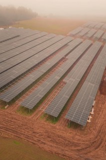 Foggy fields with solar panels, highlights rural and sustainable energy production, energy