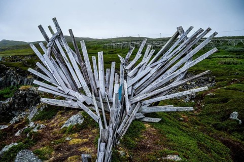 Wooden sculpture with dynamic shapes in a natural environment, Drakkar Vardø sculpture. The