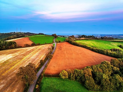 Sunset of Devon Farms and Fields over Berry Pomeroy from a drone, Totnes, England, United Kingdom