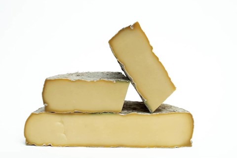 Three pieces of Saint-Nectaire cheese are stacked on top of each other. Puy de Dome. Auvergne.