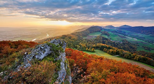 View from the Gisliflue of an autumn-colored forest, behind the Jurassic foothills with water fluh
