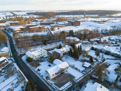 Snowy village with houses, roads and surrounding winter landscape, aerial view, Oelsburg, Ilsede