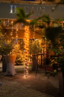 Illuminated terrace of a restaurant with fairy lights and plants in the foreground, Nagold, Calw