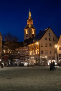 Church tower and half-timbered houses stylishly illuminated at night on a town square, Nagold, Calw