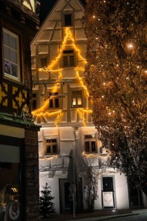 An old building is illuminated in warm lights for Christmas and gives the old town a festive light
