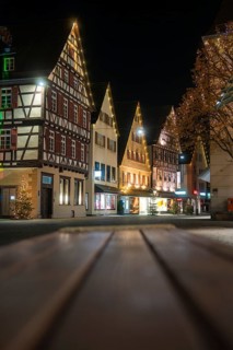 Illuminated half-timbered houses line the Old Town Street at night and create a festive atmosphere,
