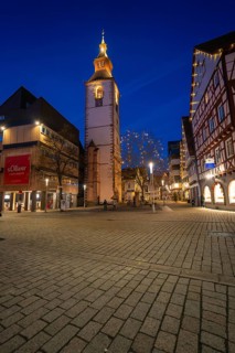 Bell tower of a church illuminated at night, surrounded by half-timbered houses, Nagold, Calw