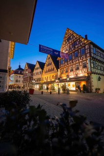 Illuminated houses with traditional architecture and ice banners at night, Nagold, Calw district,