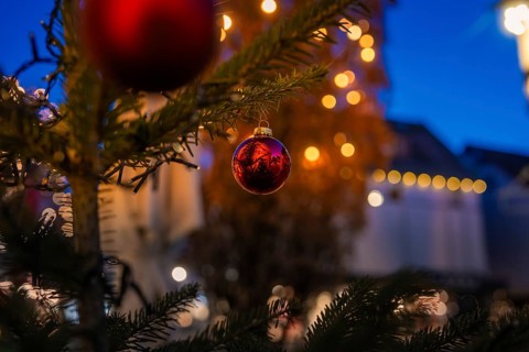 Close-up of a red Christmas ball on a tree, with blurred lights in the background, Nagold, Calw