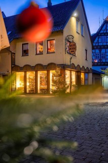 Commercial building with Christmas decoration and half-timbering at dusk, Nagold, Calw district,