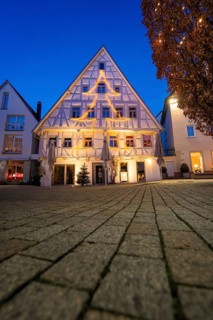 Half-timbered house with Christmas tree-shaped fairy lights against evening sky, Nagold, Calw