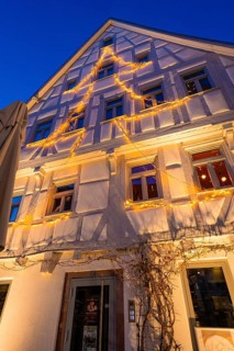Fairy lights in tree silhouette on the façade of a furnished house, Nagold, Calw district, Black