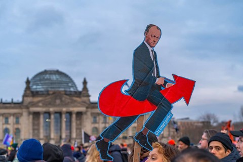 Photo of Federal Chancellor Friedrich Merz on the AfD arrow logo, demonstration against the right