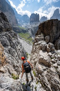 Mountaineers on a via ferrata in front of a picturesque mountain landscape with rocky peaks, Via