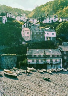 Historic buildings in harbour boats on beach at Clovelly, north Devon, England, UK 1960s