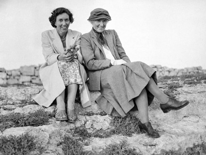 Portrait if two British women sitting on rocky surface outdoors, Malta, Europe c 1957