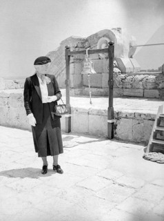 British woman, presumably a Royal Navy officer's wife, standing by ships bell of HMS Phoenicia