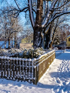Wooden fence covered with snow, plot in Berlin Lübars, Germany
