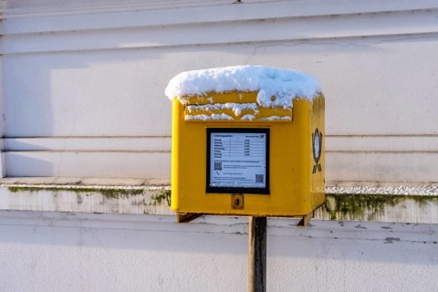 Deutsche Post mailbox covered with snow, Berlin, Germany