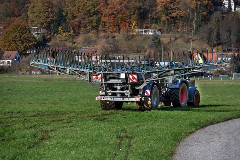 Farmer with a tow hose fertilizer in a meadow, Eschenbach, Middle Franconia, Bavaria, Germany