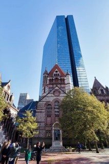 Tourist group photographs Trinity Church, glass façade of John Hancock Tower, various architectural