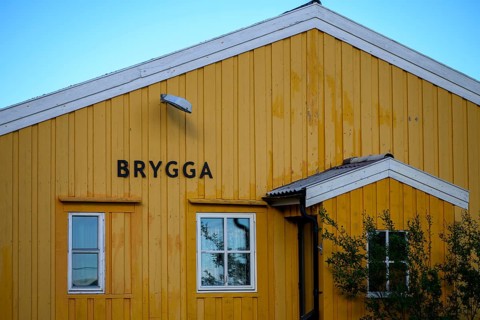 Yellow wooden building with simple, clear architecture, A yellow wooden building with two windows