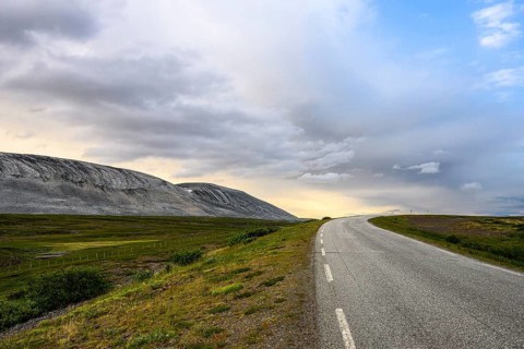 The Austertanaveien 890 winds through vast, quiet countryside, barren landscape with a winding road