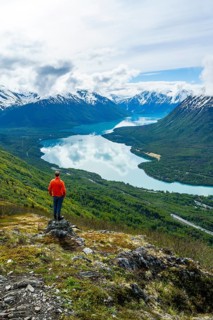 Climber enjoying the view, Slaughter Ridge Trail, view of snowy mountains and turquoise blue Kenai