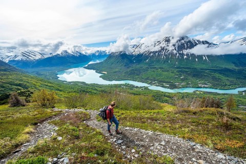 Climbers on a hiking trail, Slaughter Ridge Trail, view of snowy mountains and turquoise lake Kenai