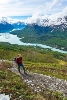 Climbers on a hiking trail, Slaughter Ridge Trail, view of snowy mountains and turquoise lake Kenai