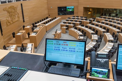 Plenary hall deserted with the seats of deputies and the government bank. Behind it is the