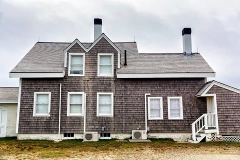 House with wooden shingles, typical architectural style, storm protection window, Highland Light,