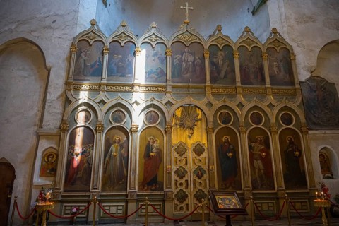 Church interior with magnificent icon wall decorated with religious paintings and golden details,
