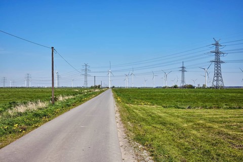 Wind turbines, power pole, overhead line, high-voltage pole, high-voltage line, road, meadows, blue