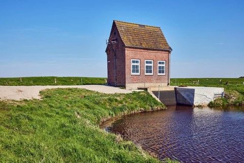 Hunnebüllerkoog, Hunnebüller Sielzug, pumping plant, façade with windows, pointed roof with red