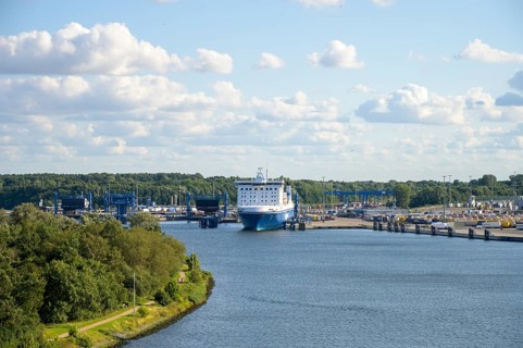 Scandinavienkai Tavemünde with large Finnlines ferry in port, surrounded by water and fluffy