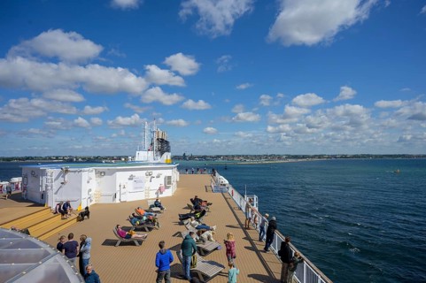 People relax on a TT-Line ship deck with a view of the sea under a blue sky, Trelleborg, Skåne län,