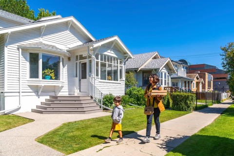 Mother and son are walking back home after picking up a food delivery order on a sunny summer day