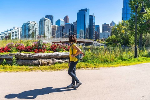Young woman enjoying a sunny summer day strolling along the scenic east village riverwalk pathway,