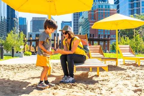 Mother and her son are spending quality time together at an urban beach in calgary, sheltered by