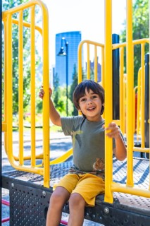 Happy child smiling and playing joyfully on a vibrant playground structure in calgary, canada,